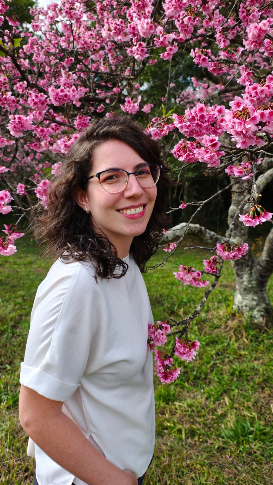 foto da daniela em jardim com flores rosas no fundo